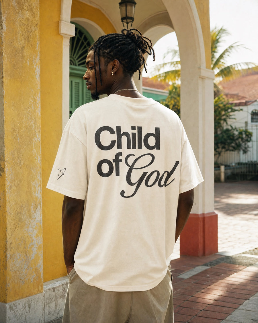 Homme vu de dos portant un t-shirt ivoire oversize imprimé « Child of God », avec pictogramme sur la manche.